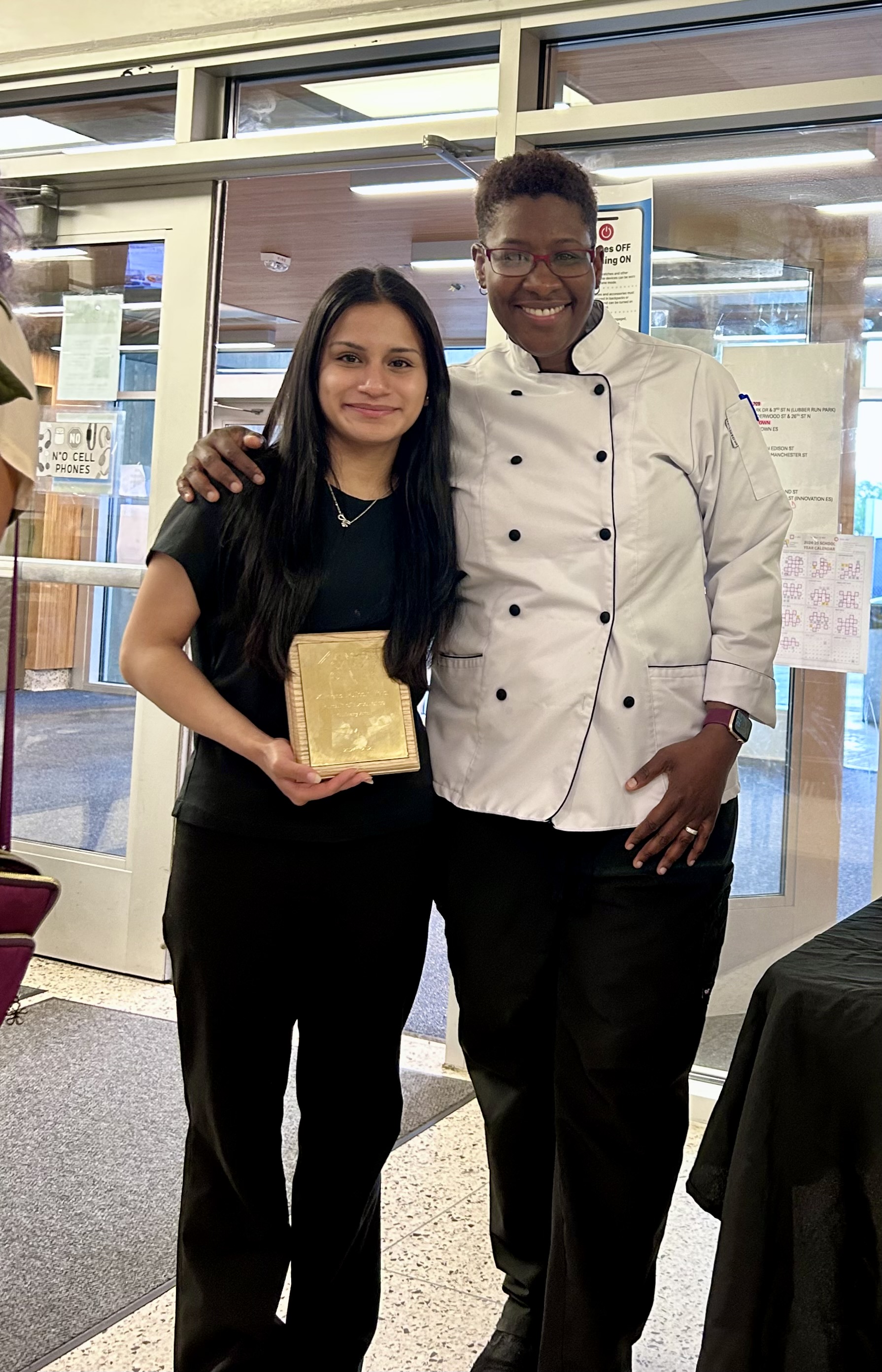 Ximena holding her award next to Chef Randolph